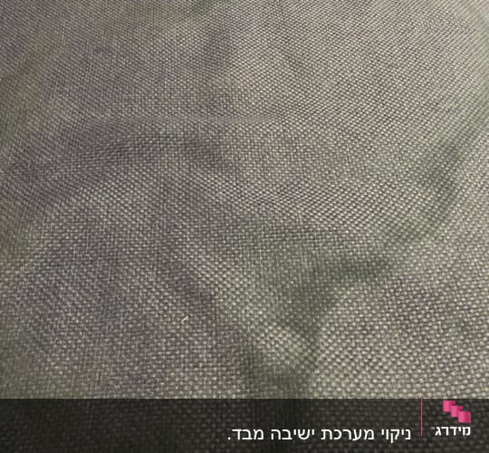 כתם כהה על בד ספה אפור